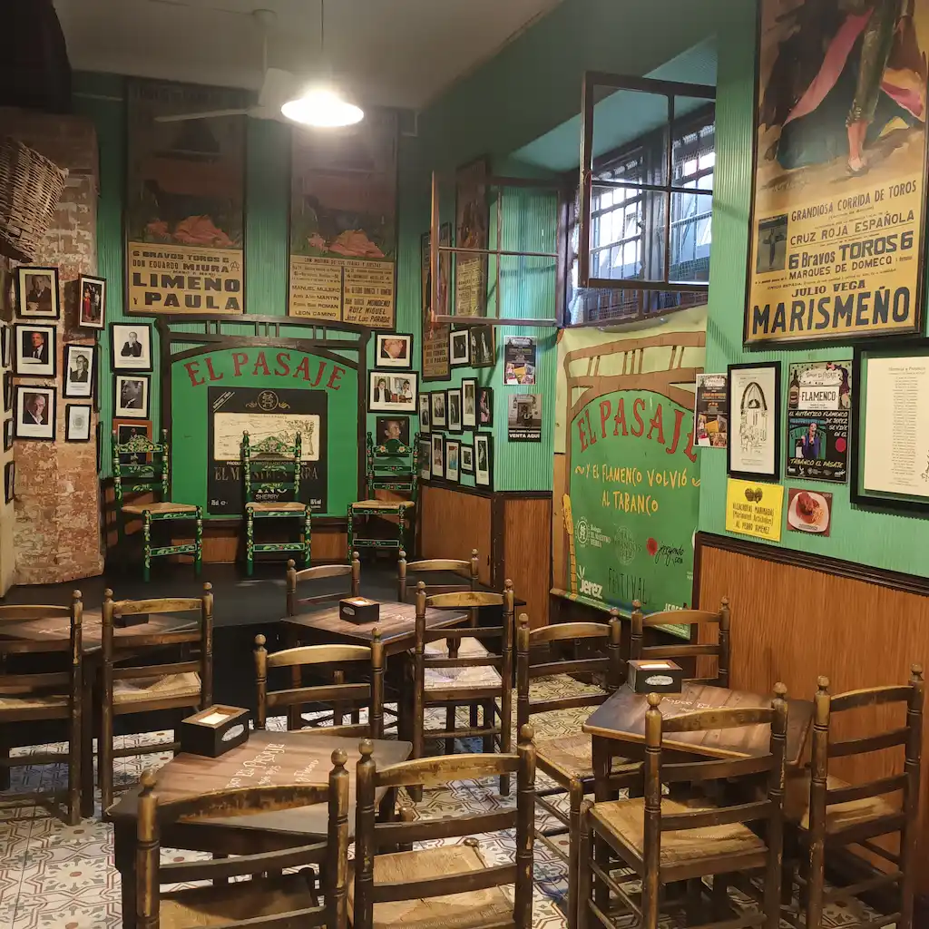 Tipica osteria antica con palco per spettacolo al fondo, piccoli tavoli in legno e sedie impagliate. Ai muri antiche foto dei ballerini con relativi cartelloni pubblicitari.