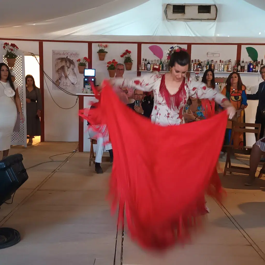 La ballerina Marga Flores mentre esegue un ballo con uno scialle di color rosso.