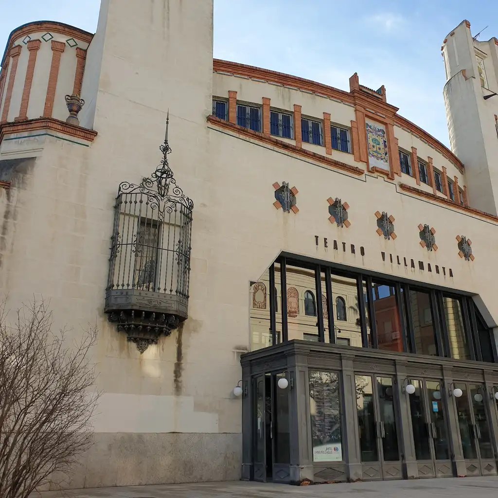 Foto facciata ingresso Teatro Villamarta. Costruzione di inizio '900 dove domina l'alternanza di elementi in ferro batturo come le grandi vetrate dell'ingresso e il balconcino laterale, ed elementi decorativi incorniciati da piastrelle di color terra tipiche del regionalismo sivigliona di inizio '900